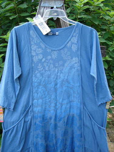 Barclay NWT Wildflower Tunic Garden Blend Blue Bird Size 0 features a scooped neckline, three-quarter sleeves with lettuce edges, and exterior front pockets, displayed on a clothes rack.