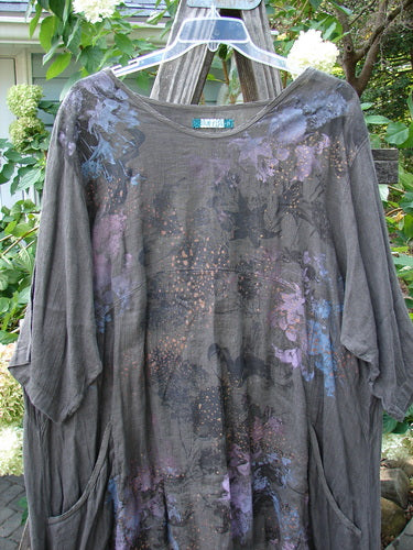 Barclay Linen Drop Pocket Urchin Dress Continuous Bouquet Wood Size 2, featuring a grey linen dress with purple and blue paint, rounded neckline, varying hemline, three-quarter sleeves, and dual exterior pockets.