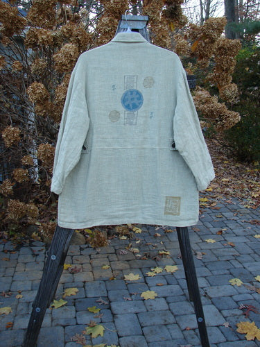 1999 Hemp Yard Coat Far East Cement Size 1 displayed on a stand, featuring thick metal buttons, triangular front pockets, and adjustable side tabs, showcasing its heavy-weight cotton hemp and flannel composition.