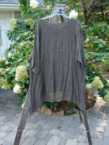 Barclay Linen Drop Pocket Urchin Dress Continuous Bouquet Wood Size 2 displayed on a wooden rack, showcasing its three-quarter sleeves, rounded neckline, and dual exterior pockets.