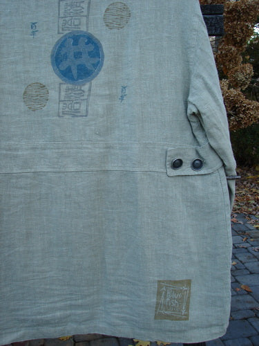 1999 Hemp Yard Coat Far East Cement Size 1: A close-up of a heavy-weight cotton hemp coat with metal buttons and triangular front pockets.