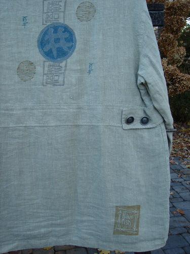 Close-up of the 1999 Hemp Yard Coat Far East Cement Size 1, showcasing heavy cotton hemp outer, soft flannel inner, thick metal buttons, and front drop painted pockets, highlighting its substantial weight and texture.