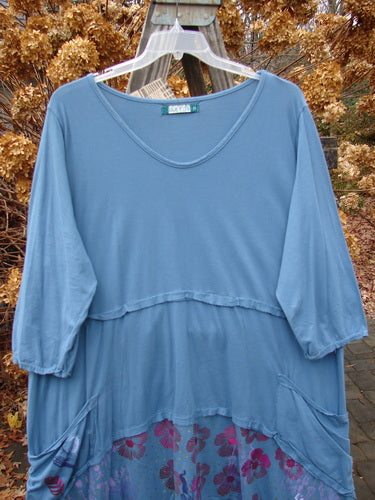 Barclay NWT Raw Seam Vector Dress in Whistler Blue, displayed on a hanger, featuring a V neckline, raw edges, varying hemline, and front pockets with a floral theme. Size 2.