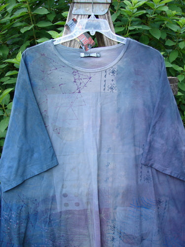 Barclay NWT Art Tee Celestial Mottled Purple Blues OSFA displayed on a hanger, showcasing its tunic length, drop shoulders, and three-quarter sleeves with a distinctive varying hemline.
