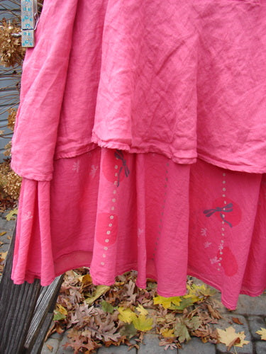 Barclay Linen Two Tier Ruffle Skirt Tiny Dragonfly Peony Size 2, displayed on a wooden pole, showcasing its double-layered ruffle design with a unique dragonfly theme and adjustable elastic waistline.