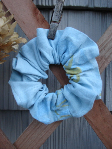 2000 PMU Linen Hemp Button Hair Scrunchie Abstract Sun Water Small, showcased on a wooden surface, features ruffled fabric with an abstract sun design, embodying Bluefishfinder.com's sustainable, vintage-inspired ethos.