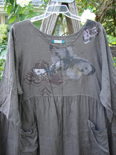Barclay Linen Two Pocket Dolly Dress Butterfly Wood Size 2, featuring a flouncy lower skirt, dropped empire waist, wide hem sweep, dual lower exterior drop pockets, and a butterfly theme painted on lightweight linen.