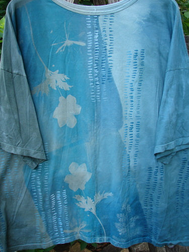 Barclay Center Seam Wide Line Tee Floral Path Mottled Turq OSFA, featuring a boxy shape, significant drop shoulders, and a distinctive floral pattern on medium-weight organic cotton with a vertical center seam.