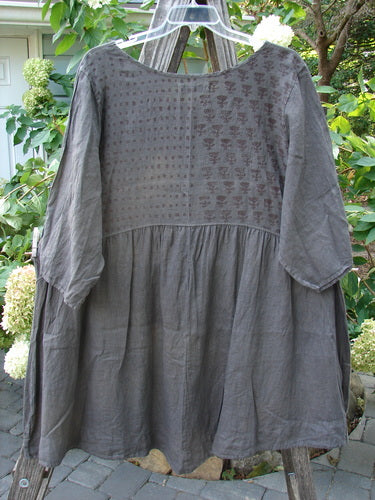 Barclay Linen Two Pocket Dolly Dress Butterfly Wood Size 2 on a hanger, featuring a flouncy lower skirt, dropped empire waist, wide hem sweep, and butterfly-themed painted upper rear bodice.