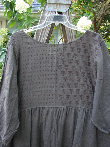 Barclay Linen Two Pocket Dolly Dress Butterfly Wood Size 2 displayed on a wooden swing, featuring a flouncy lower skirt, dual exterior pockets, and a butterfly-themed upper painted rear bodice.