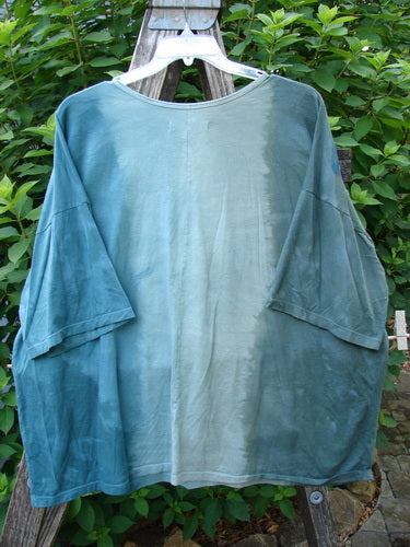 Barclay Center Seam Wide Line Tee Floral Path Mottled Turq OSFA displayed on a hanger, showcasing its rounded neckline, drop shoulders, and wide, boxy shape with a vertical center seam.