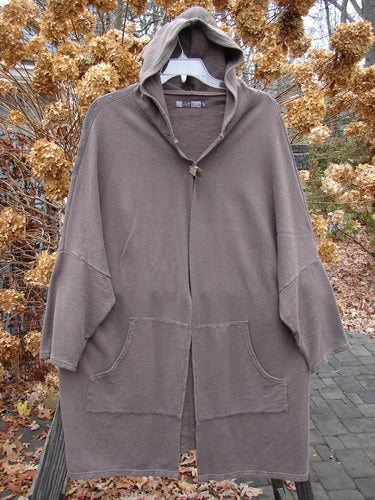 Barclay Hemp Cotton Open Front Hooded Cloak Twig Stone OSFA displayed on a hanger, featuring a cozy hood, kangaroo front pockets, dolman sleeves, and twig-themed back design.