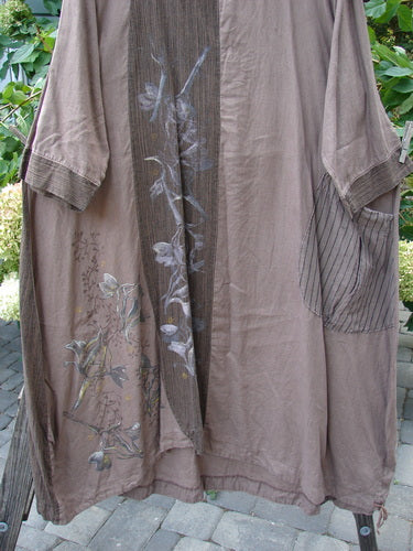 Barclay Linen Gathered Hem Single Pocket Dress Tall Sprig Sand Stone Size 2, featuring a floral design, rounded neckline, sectional vertical panels, and a lower hem drawcord, modeled standing outdoors.