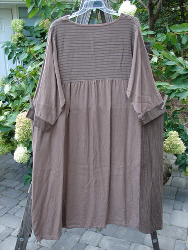 Barclay Linen Gathered Hem Single Pocket Dress Tall Sprig Sand Stone Size 2 displayed on a swing, showcasing its A-line shape, three-quarter sleeves, and distinctive sectional vertical panels with a sprig pattern.