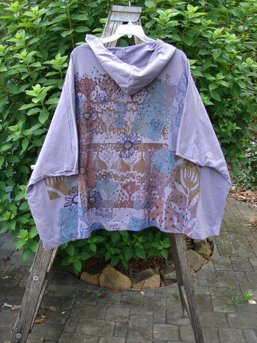 Barclay NWT Hooded Postcard Zipper Jacket Vest Rear Daisy Violet OSFA displayed on a wooden stand, highlighting its generous hood, full zipper, roomy pockets, dolman shoulders, and daisy-themed rear design.