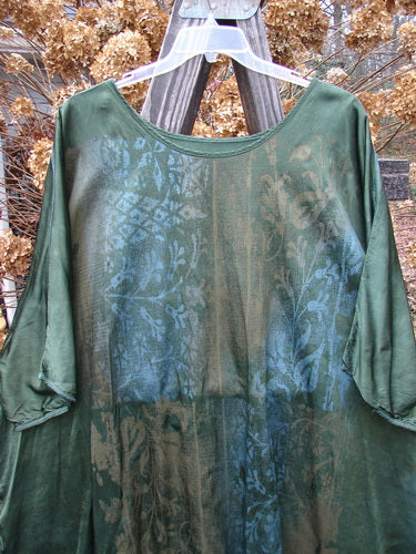 Barclay Viscose Hi Low Tunic Wildflower Forest Sun Size 2, featuring a rounded neckline, varying hem, vented sides, three-quarter dolman sleeves, and a wildflower pattern.