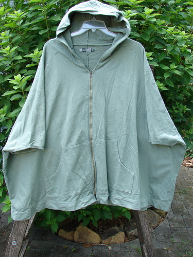 Barclay Hooded Postcard Zipper Jacket Vest Rear Garden Trellis Sage OSFA features a cozy hood, full zipper, dolman shoulders, and a sweeping hemline with unique rear garden trellis design details.