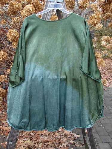 Barclay Viscose Hi Low Tunic Wildflower Forest Sun Size 2 on a clothes rack, showcasing a rounded neckline, three-quarter dolman sleeves, varying hem, and wildflower pattern.