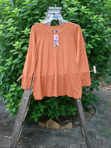 Barclay NWT Modal Slub Layer Top Unpainted Ember Size 0 displayed on a clothes rack, showcasing its long sleeves, rounded neckline, and raw edges, embodying Bluefishfinder.com's vintage clothing essence.