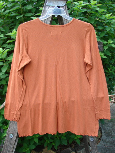 Barclay NWT Modal Slub Layer Top Unpainted Ember Size 0, features long narrow sleeves, A-line shape, raw edges, rounded neckline, displayed on a clothesline, reflecting Bluefishfinder.com's ethos of creative individual expression.