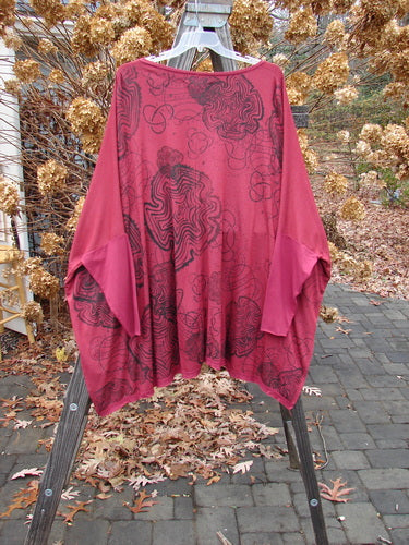 Barclay NWT Rayon Lycra Celebration Cardigan Spirograph Rouge OSFA displayed on a rack, featuring an open front, flutter hem, and unique spirograph design on the back.