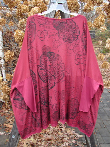 Barclay NWT Rayon Lycra Celebration Cardigan Spirograph Rouge OSFA, displayed on a clothesline, featuring an open front, flutter hem, and intricate black spirograph designs.