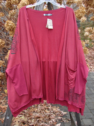 Barclay NWT Rayon Lycra Celebration Cardigan Spirograph Rouge OSFA displayed on a hanger, showcasing its open front, flutter hem, three-quarter sleeves, and single lower pocket.