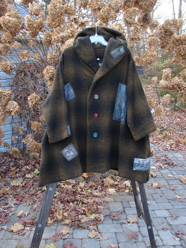 1995 Patched Hooded Autumn Jacket Music Man Cottage Brown Plaid OSFA displayed on an outdoor swinger, showcasing its large buttons, deep side pockets, and cozy double-lined hood.