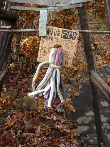 New SINGLE Rippie Pack One Size featuring a blue fish illustration on a sign, showcasing colorful fabric elements for creative styling options in hair, buttons, or drapes.