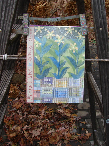 2000 Spring 1 Catalog Growth One Size displayed on a chair, featuring close-ups of artistic elements and brown leaves, highlighting vintage Blue Fish Clothing's creative and expressive designs.