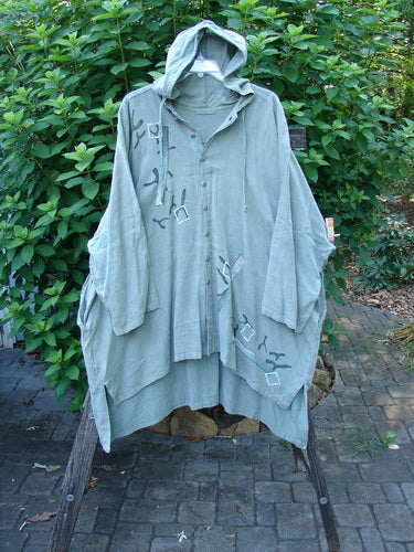 1997 Linen Seaspray Jacket Bamboo Lagoon Size 3: Features an oversized drawcord hood, dolman sleeves, shirttail hemline, metal buttons, and bamboo theme painting; minimal sleeve fade visible.