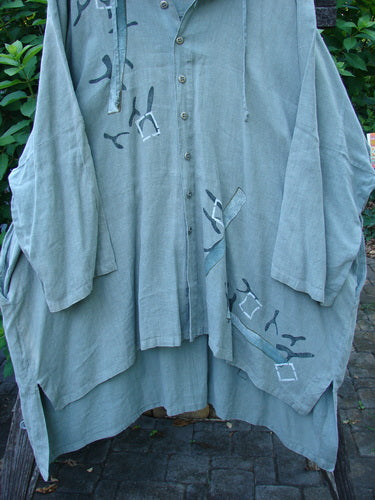 1997 Linen Seaspray Jacket Bamboo Lagoon Size 3 features an oversized floppy drawcord hood, dolman sleeves, generous shirttail hemline, and a bamboo theme design, showcasing vintage Blue Fish creativity.