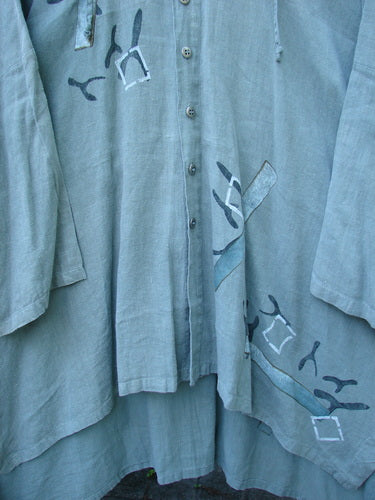 Close-up of the 1997 Linen Seaspray Jacket Bamboo Lagoon Size 3, showcasing medium-weight linen with a floppy drawcord hood, dolman sleeves, and classic bamboo paint theme, highlighting its vintage charm.