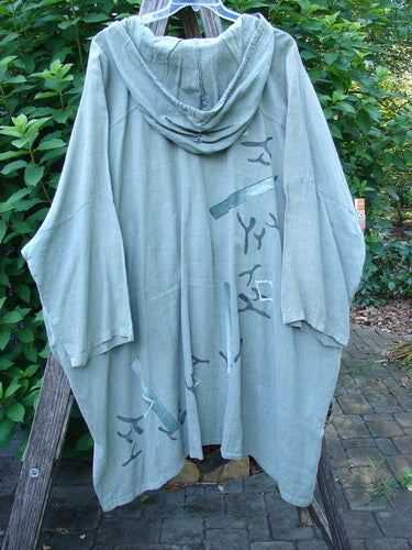 1997 Linen Seaspray Jacket Bamboo Lagoon Size 3 features an oversized drawcord hood, dolman sleeves, and metal buttons. The jacket showcases a bamboo paint theme and a boxy shape with a shirttail hemline.
