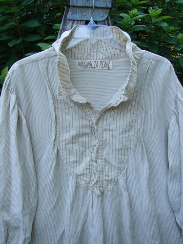 Magnolia Pearl Linen Crop Artist's Pocket Pullover features a light pin-striped design with a ruffled collar, lace detailing, and a button placket, embodying vintage style from Bluefishfinder.com.