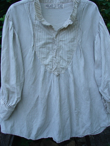 Magnolia Pearl Linen Crop Artist's Pocket Pullover features a flowing, tunic-length design with a ruffled bib-front, gathered shoulders and cuffs, and a Henley button front, embodying Bluefishfinder.com's vintage, expressive style.