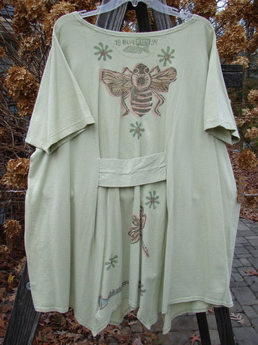 A 1994 Leaf Top Music Garden Aloe Size 2: A green robe with a bee on it, featuring a close-up of a dress, a drawing of a bee, a close-up of a tail fin, and a close-up of a bird's feet.