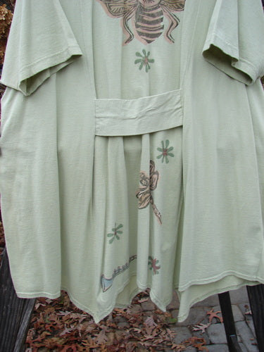 1994 Leaf Top Music Garden Aloe Size 2: A close-up of a green robe with a unique painted 4 point hemline and a super big tailored swing.