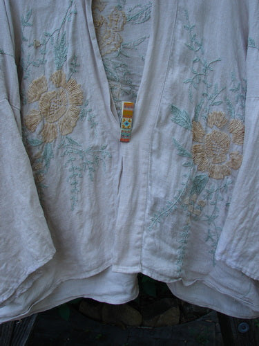Magnolia Pearl Linen Embroidered Claudio Kimono Lilac Water OSFA features an open front, dolman shoulders, and floral embroidery, showcasing a widening shape and wide three-quarter sleeves, embodying Bluefishfinder's vintage style.