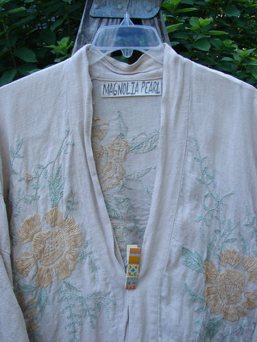 Magnolia Pearl Linen Embroidered Claudio Kimono Lilac Water OSFA features intricate pastel floral embroidery on medium-weight linen, showcasing three-quarter length sleeves and a stand-up collar, embodying Bluefishfinder.com's unique vintage style.