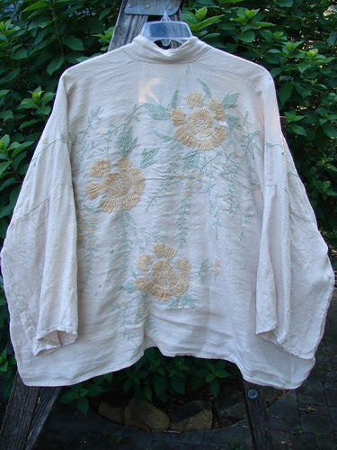 Magnolia Pearl Linen Embroidered Claudio Kimono Lilac Water OSFA features delicate pastel floral embroidery on white fabric, with a widening shape, dolman shoulders, and swingy three-quarter sleeves, reflecting BlueFishFinder's unique vintage aesthetic.