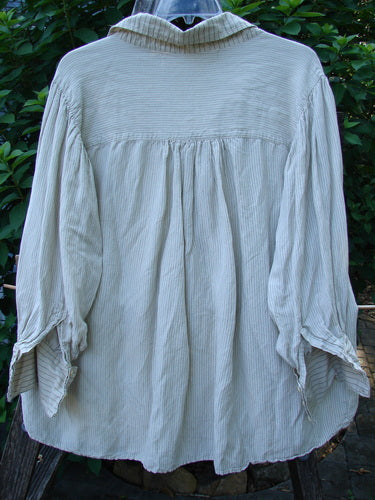 Magnolia Pearl Linen Crop Artist's Pocket Pullover showcases a lightweight, finely striped fabric with a stand-up collar and yoke. Features include billowy drape, three-button cuffs, and a signature interior label.