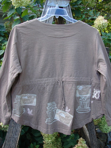 1999 Coffee Top Fancy Pot Riverbed Size 1 features a brown shirt with artistic drawings, including a tree trunk motif, showcasing a rounded hemline and big button closures in perfect condition.