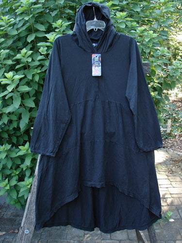 Barclay NWT Hi Low Hooded Pocket Tunic features a cordless hood, raw-edged sleeves, and dual side pockets. The tunic showcases a wide, flared swing with an empire waist and tiered design.