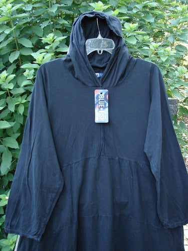 Barclay NWT Hi Low Hooded Pocket Tunic in black displayed on a hanger, showcasing its wide flared swing, cordless hood, raw-edged sleeves, and dual front pockets, reflecting Bluefishfinder.com's vintage style.