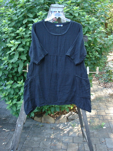 Barclay NWT Gauze Seaside Tunic Dress Unpainted Black Size 0 displayed on a wooden rack, showcasing its flutter neckline, drop shoulders, wide sleeves, and varied hemline, embodying Bluefishfinder.com's vintage style.