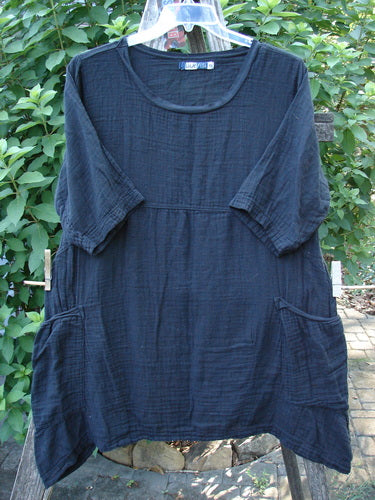 Barclay NWT Gauze Seaside Tunic Dress Unpainted Black Size 0 features a scooped flutter neckline, drop shoulders, wide short sleeves, and dual drop pockets, showcased on a clothesline.