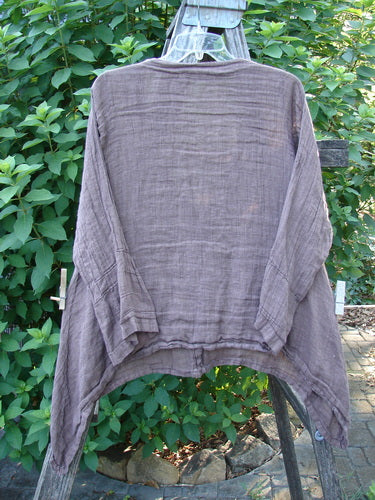 Barclay Linen Deep V Neck Three Button Top Unpainted Peat Size 0 on a rack, showcasing its lightweight linen texture, three-button front, and unique hemline, embodying BlueFishFinder's vintage, expressive style.