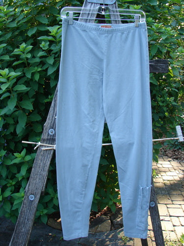 Barclay Cotton Lycra Side Gather Legging Unpainted Grey Grass Size 1 hanging on a clothesline, showcasing its full thinner elastic waistband and tapering lowers with exterior drawcords.