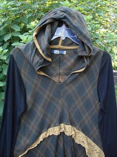 Barclay Rayon Linen Ruffle Pocket Dress in brown plaid, featuring a hi-low hemline, ribbed sleeves, and a light hoodie. Designed with lace accents and drop pockets, ideal for vintage fashion enthusiasts.